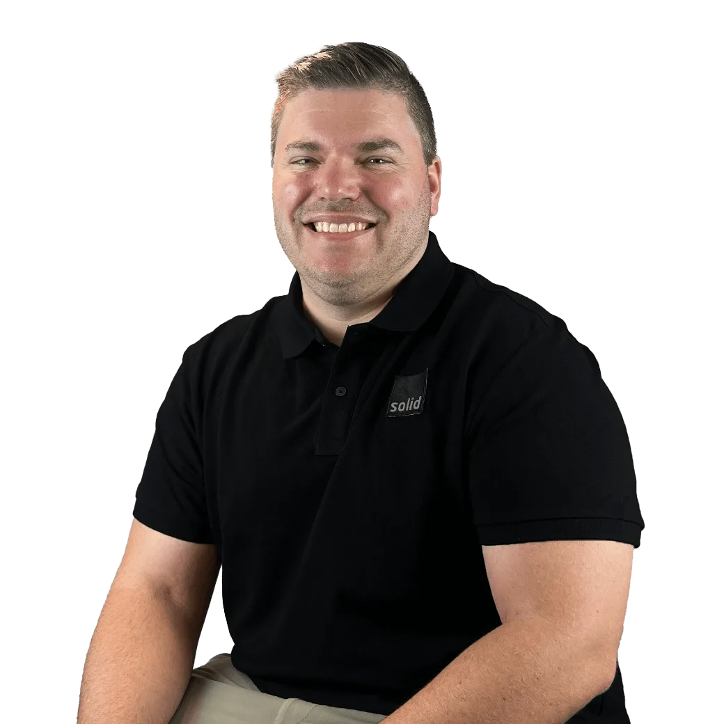 Reece from the Solid Systems team, smiling in a Solid polo shirt
