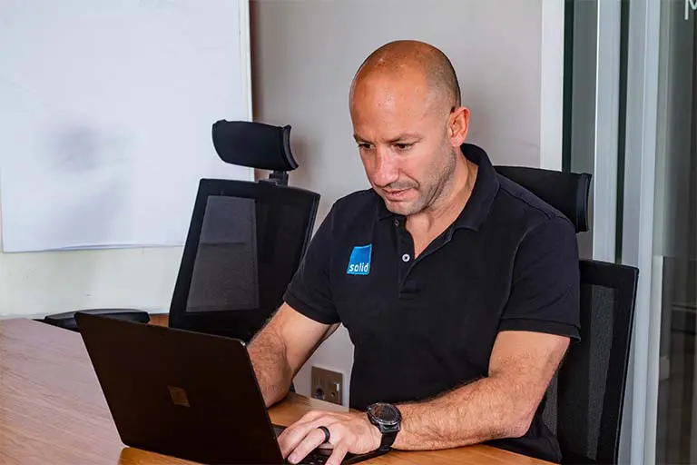 Solid Systems co-founder working on a laptop in a meeting room